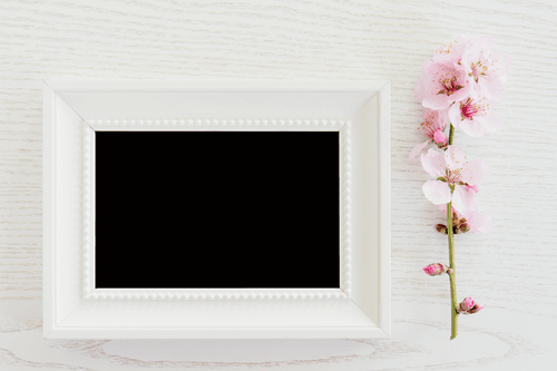 White Frame Mockup On A Wooden Table With Flower
